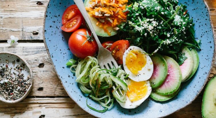 poached egg with vegetables and tomatoes on blue plate